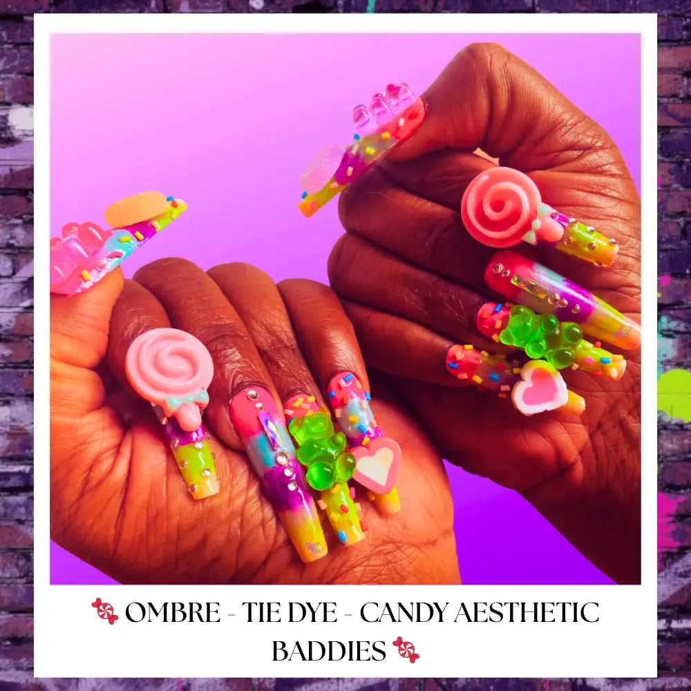 Close-up of rainbow candy-themed press on nails with 3D gummy bears, lollipops, sprinkles, and bright neon ombré colors on dark skin hands against a purple background.