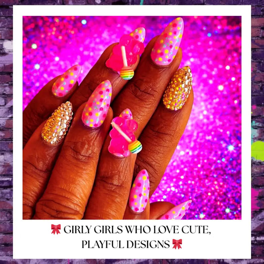 Candy cake press-on nails with pastel polka dots, 3D lollipop charms, rhinestone accents, and glossy pink finish on a bold colorful background