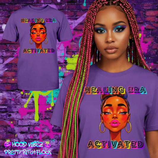 Woman wearing a purple 'Healing Era Activated' t-shirt with colorful design against a graffiti-covered wall.