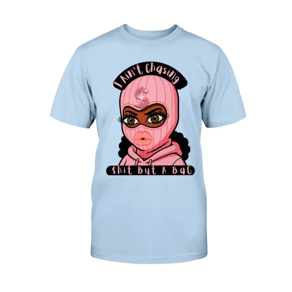 “Light blue t-shirt with cartoon baddie wearing a pink ski mask and hoodie, with text reading ‘I Ain’t Chasing Shit But a Bag’ in black and pink.”