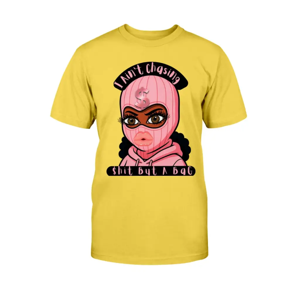 “Yellow t-shirt with cartoon baddie wearing a pink ski mask and hoodie, with text reading ‘I Ain’t Chasing Shit But a Bag’ in black and pink.”