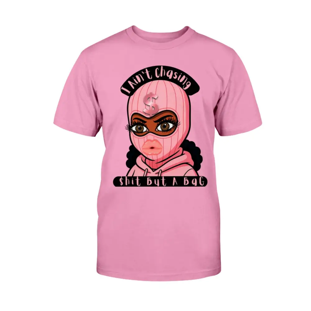 “Pink t-shirt with cartoon baddie wearing a pink ski mask and hoodie, with text reading ‘I Ain’t Chasing Shit But a Bag’ in black and pink.”