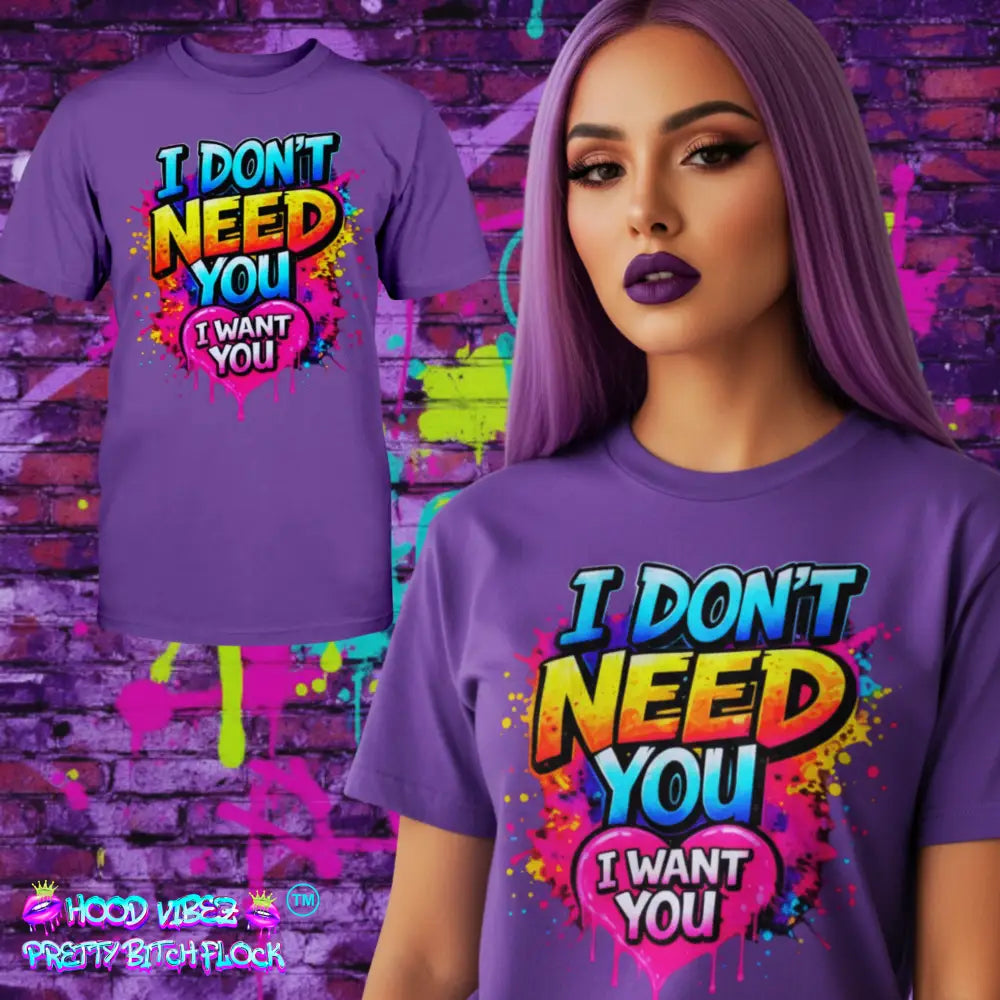 Purple t-shirt with colorful text "I Don't Need You" with a heart design that says I Want You design worn by a model against a graffiti-covered wall.