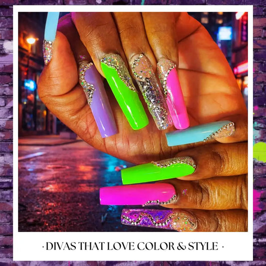 Close-up of long neon press on nails in bright green, pink, purple, and aqua with rhinestone cuticle accents and glossy finish on hands.
