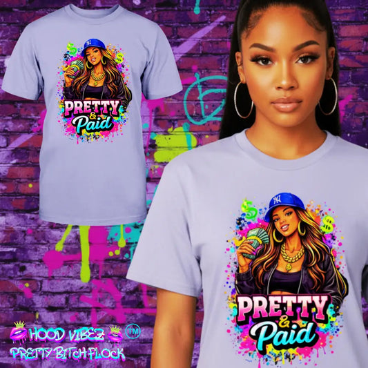 T-shirt with 'Pretty & Paid' graphic design featuring a woman wearing a cap, against a colorful graffiti wall background.