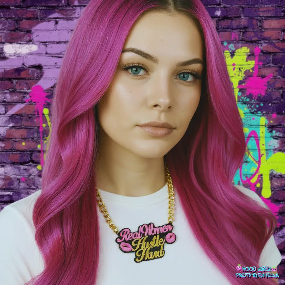 Real Women Hustle Hard statement necklace featuring pink and gold lettering with lip accents on a gold-tone chain against a yellow background.