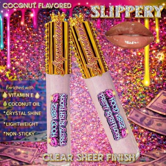Two clear glitter-infused lip gloss tubes with gold caps displayed on an urban graffiti night background with cash and diamond accents, showcasing a high-shine, crystal-clear lip gloss.