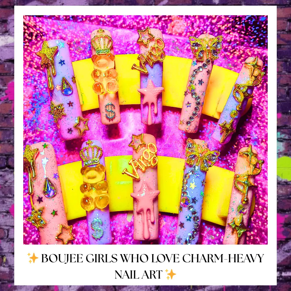 Long pink and purple press-on nails decorated with glitter, charms, stars, butterflies, crowns, drips and “Virgo” accents displayed on a yellow stand with a sparkly pink background; caption reads “Boujee girls who love charm-heavy nail art.”