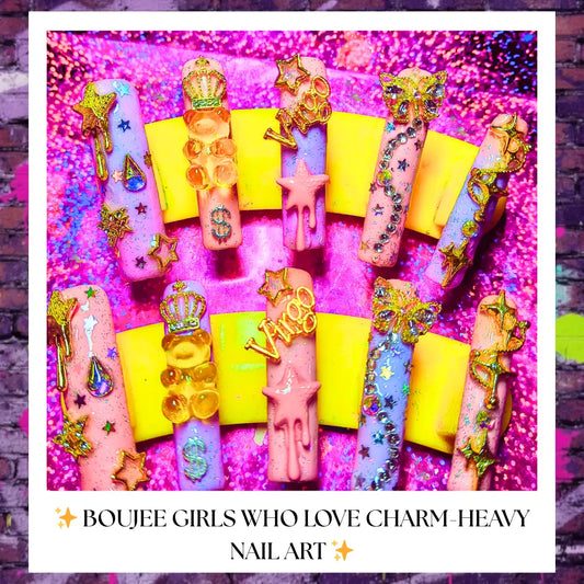 Long pink and purple press-on nails decorated with glitter, charms, stars, butterflies, crowns, drips and “Virgo” accents displayed on a yellow stand with a sparkly pink background; caption reads “Boujee girls who love charm-heavy nail art.”