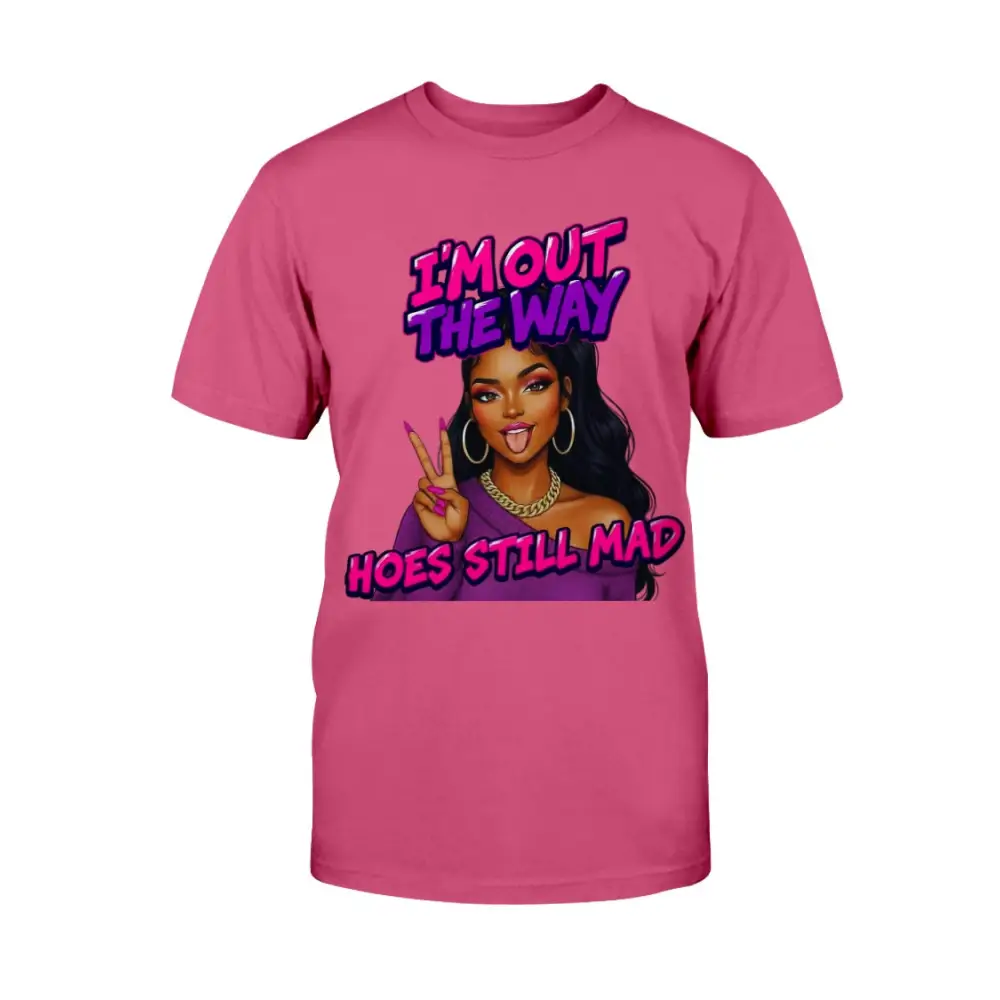 A pink t-shirt featuring a cartoon-style Black woman with long hair, hoop earrings, gold chain, and pink nails flashing a peace sign, with bold pink and purple text that reads “I’m Out the Way, Hoes Still Mad.”"