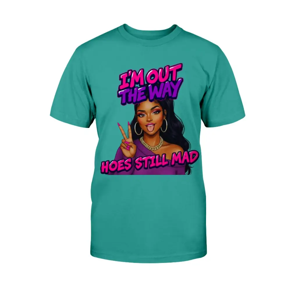 A teal t-shirt featuring a cartoon-style Black woman with long hair, hoop earrings, gold chain, and pink nails flashing a peace sign, with bold pink and purple text that reads “I’m Out the Way, Hoes Still Mad.”"