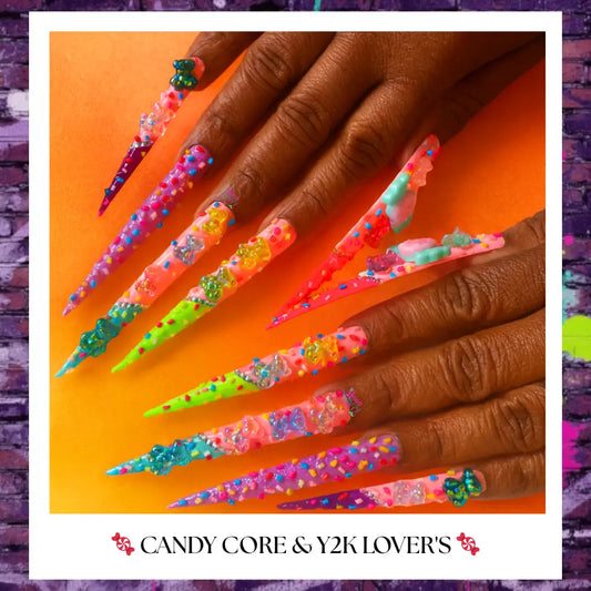 Rainbow candy press on nails with 3D bubble and gummy charms, extra-long stiletto shape, displayed on hand against warm background.